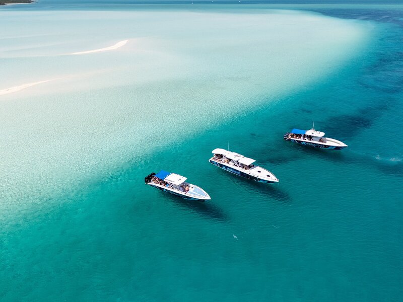 Aerial photo of three aqua shores tour boats out in the sea