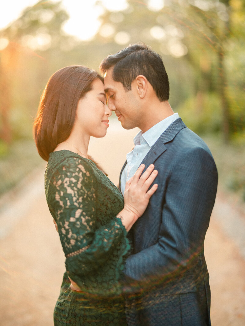 A couple standing in a grassy area about to kiss