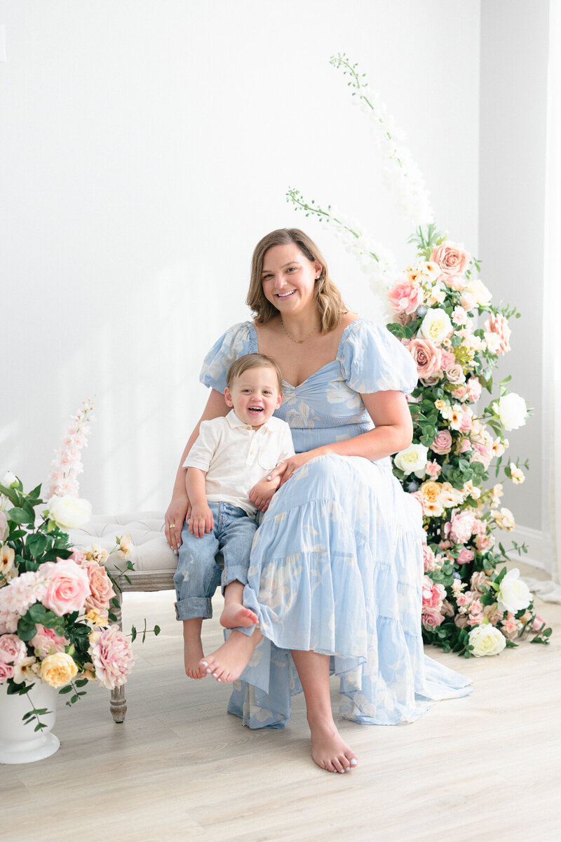 Portrait of a mom sitting on a bench with her little boy during her louisville family photo session with missy marshall photography