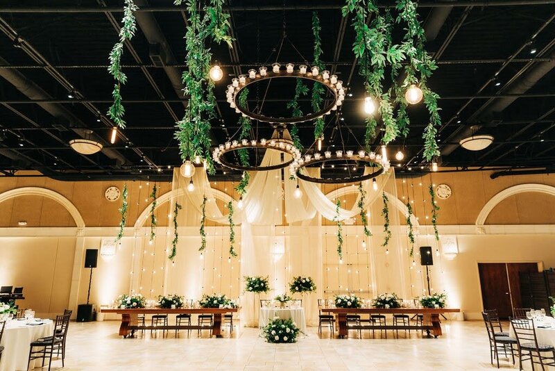 A wedding reception adorned with hanging greenery, creating a natural and elegant ambiance.