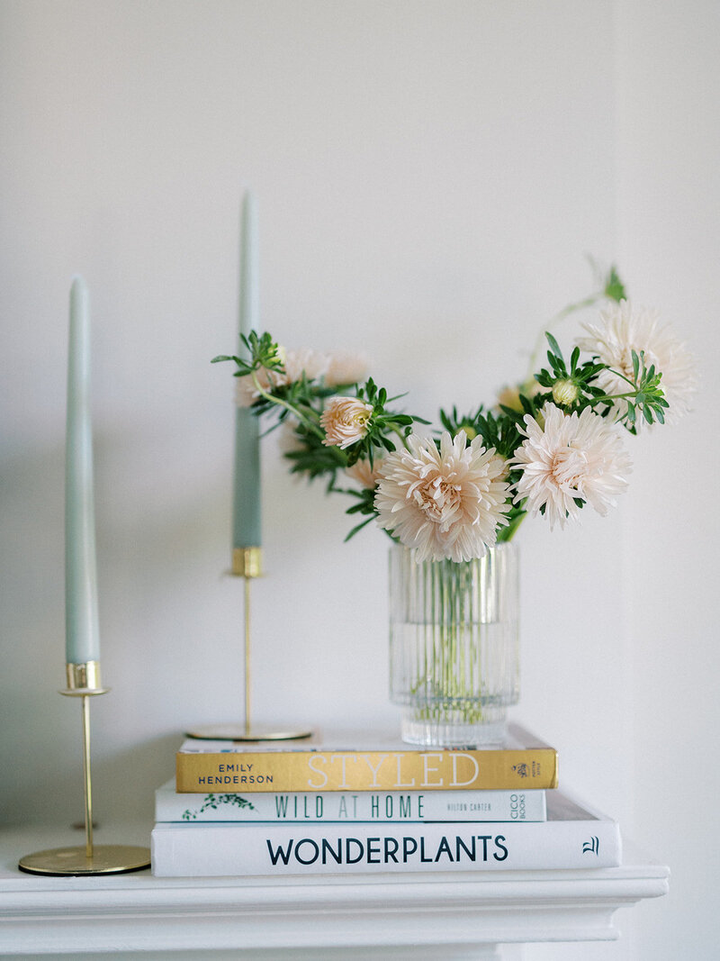 Blush mums on top of books with taper candles
