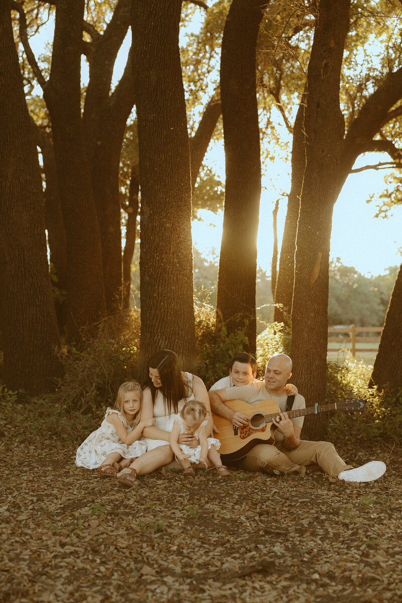Golden hour family session with a guitar in a field in Buffalo Gap, TX