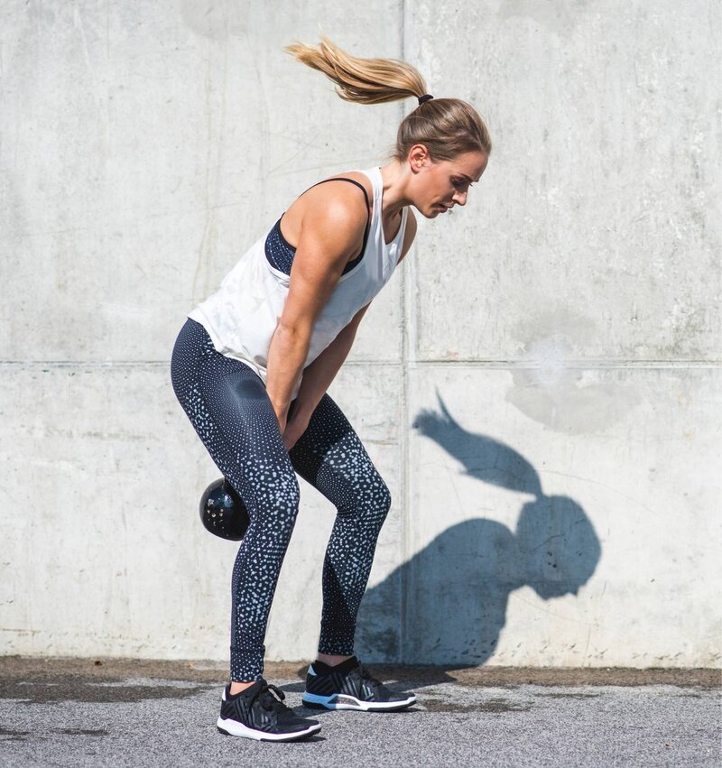 Woman performing a kettlebell swing outdoors as part of Rebells™ strength training for women over 40—featured in the Menopause.Rescripted membership to support strength and long-term health.