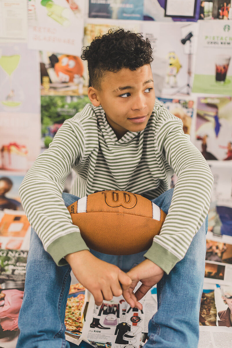 young boy poses for portraits with football at the gathering place in las vegas