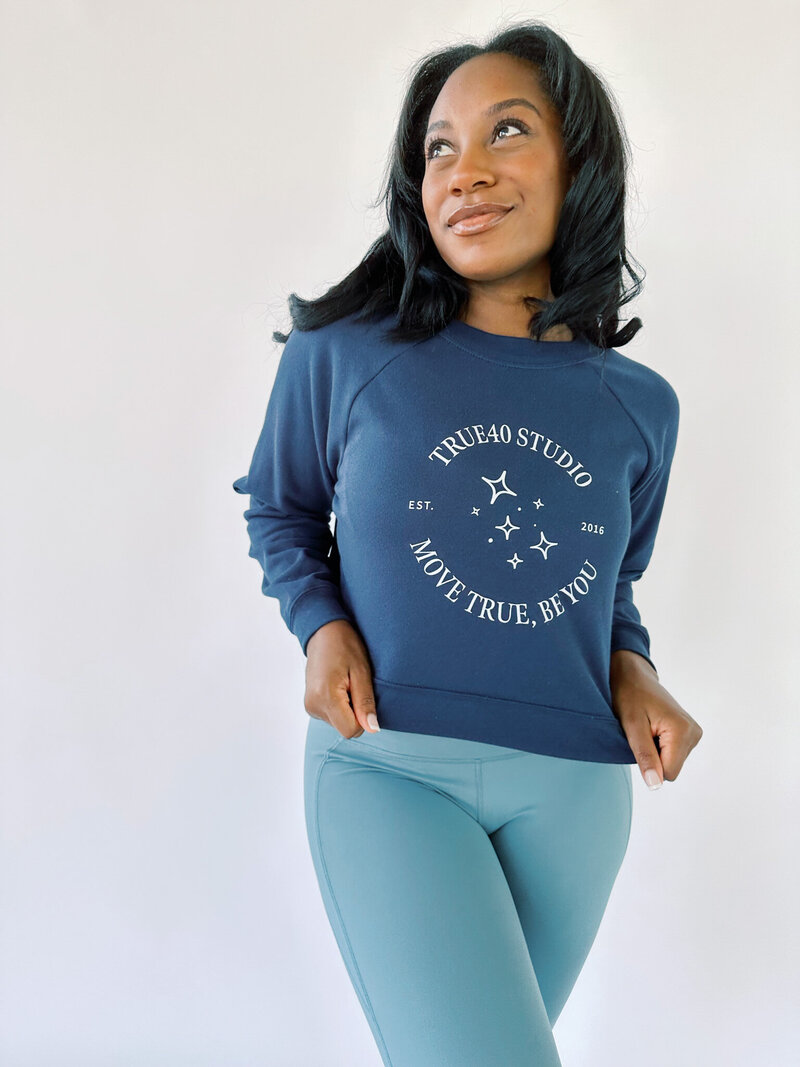 Woman wearing a navy cropped True40 sweatshirt with logo