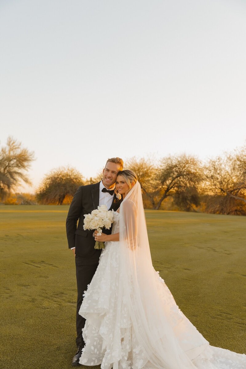 bride and groom pose for portraits after wedding ceremony in phoenix