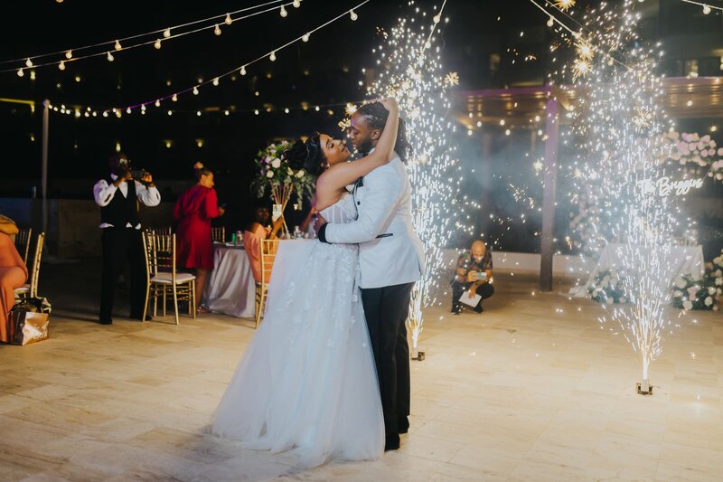 A bride and groom share their first dance under sparklers.