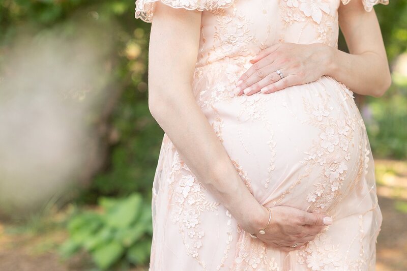 Close up detail shot of expecting mother holding belly in blush dress at Chicago Maternity Session