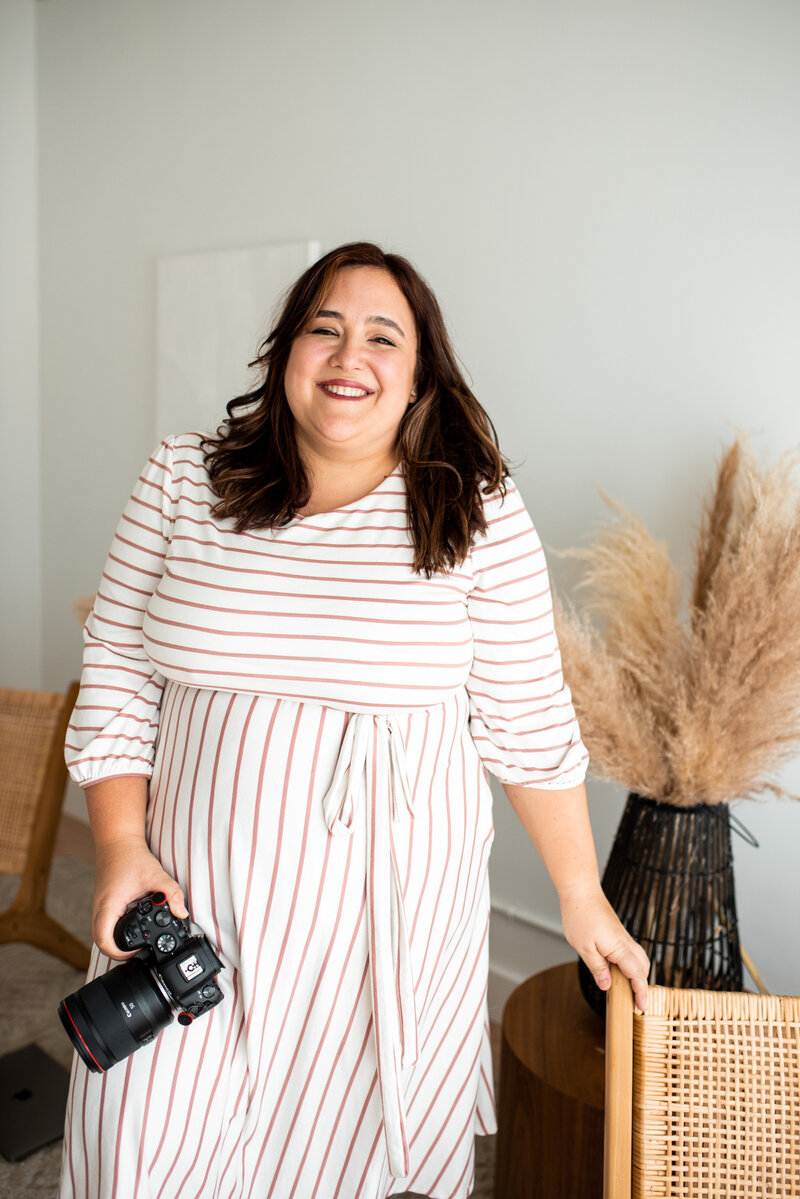 Solo portrait of personal brand photographer, Valerie Doucette, with her camera.