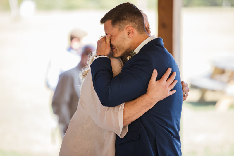 groom hugging mother and crying during first dance