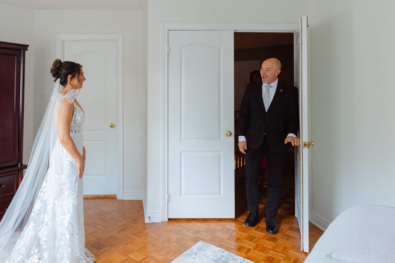 a father of the bride seeing his daughter as a bride and smiling.  Captured by Ottawa wedding photographer JEMMAN Photography