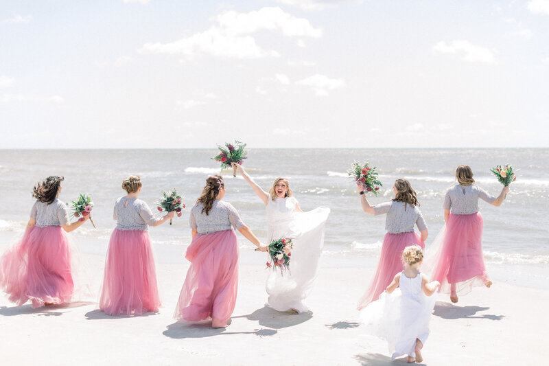 portrait of bridesmaids dancing on the beach