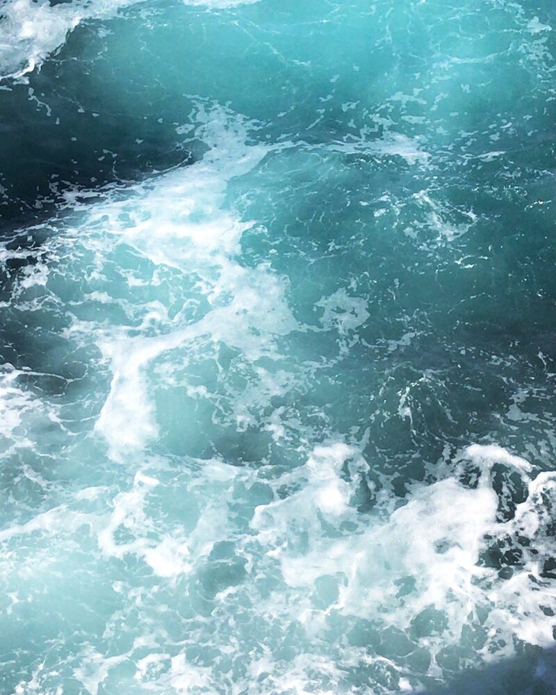 Turquoise waves crashing to make white marbled ocean curface