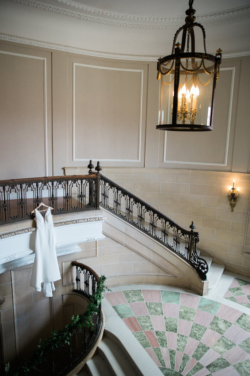 wedding dress hanging in stairwell