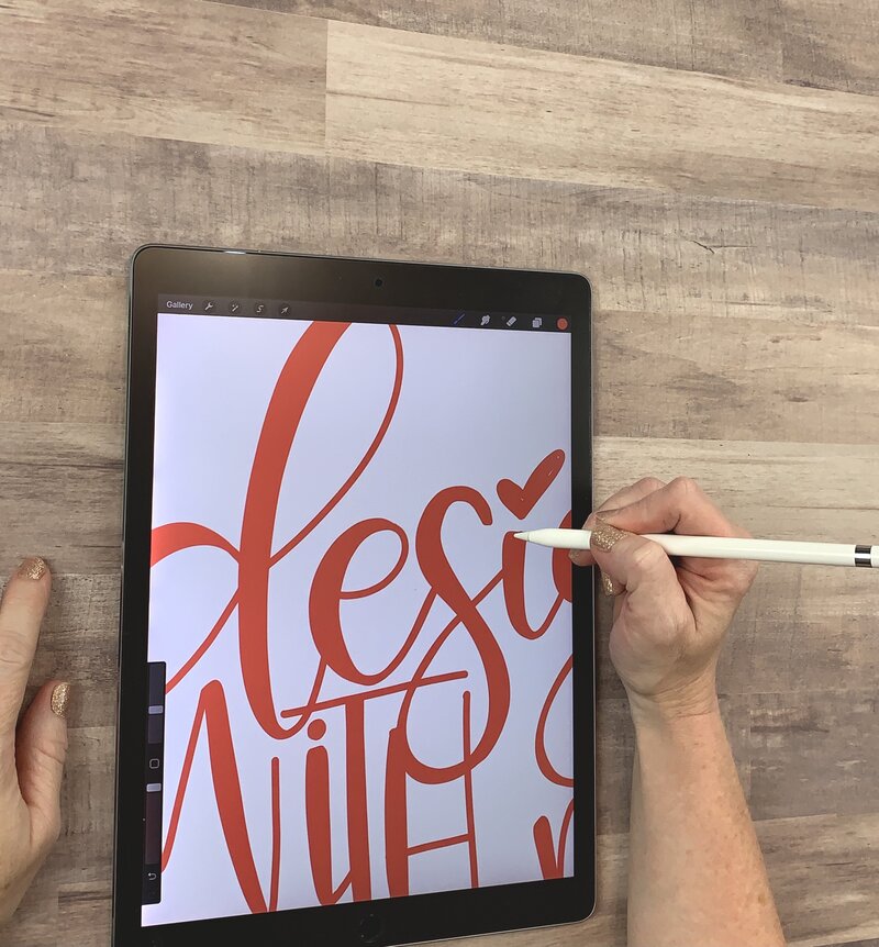 Woman drawing on iPad with red letters and white background
