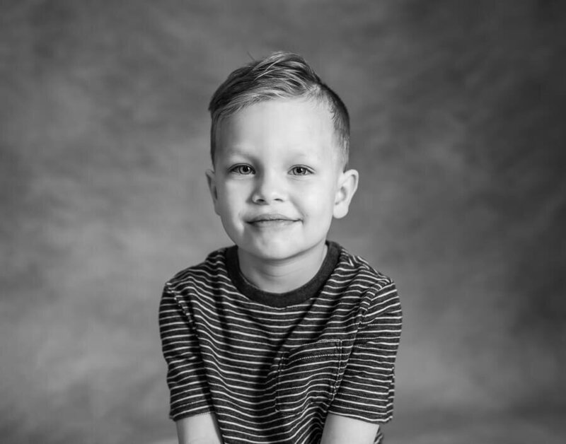 A child poses in a striped shirt.