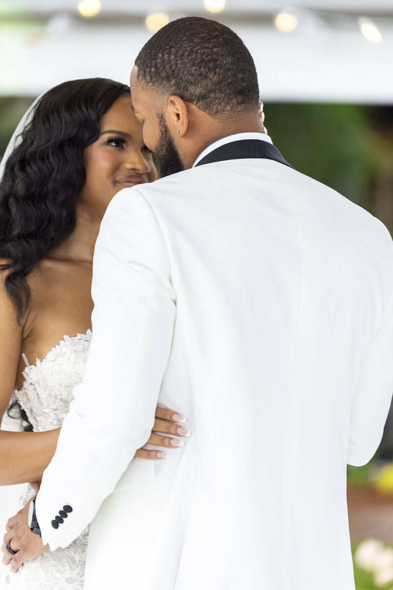 black bride in black sequin dress with hand on chair and other hand on thigh