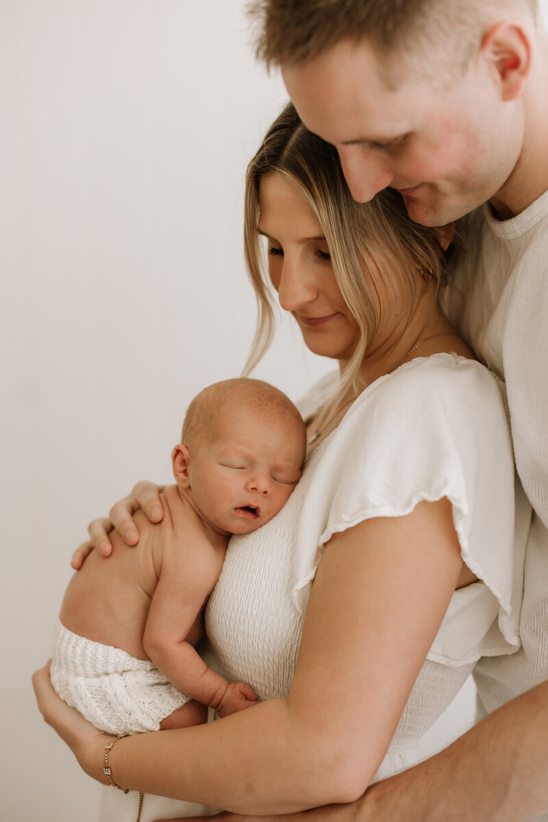 new family sitting in nursery with dog