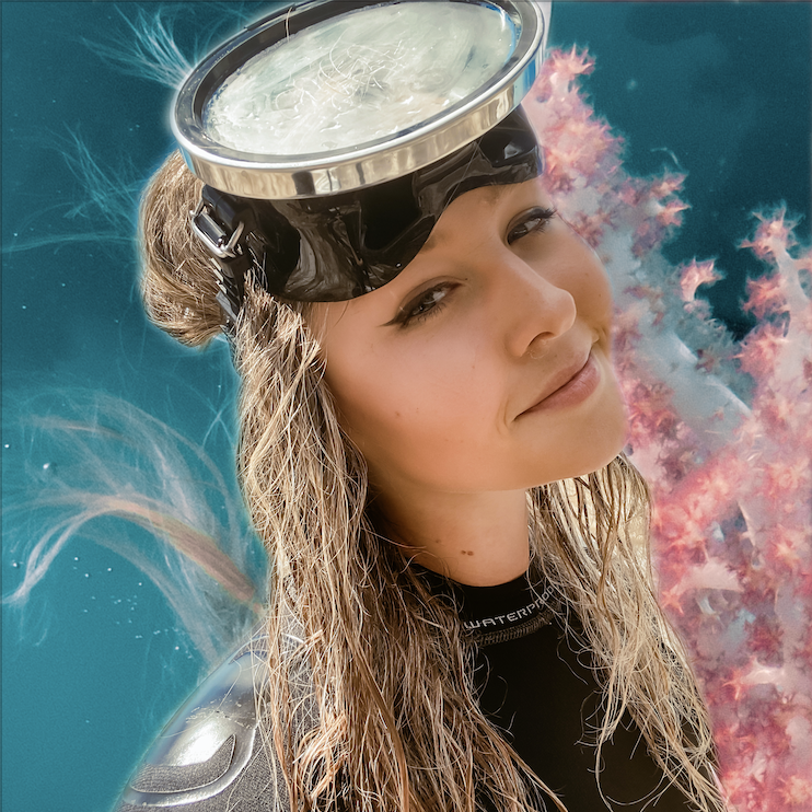 Old fashioned diving mask on forehead on blonde girl with wet hair smiling at camera, ocean and coral background
