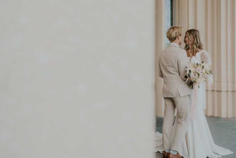 Couple holding each other close outside the doors of Utah  Temple