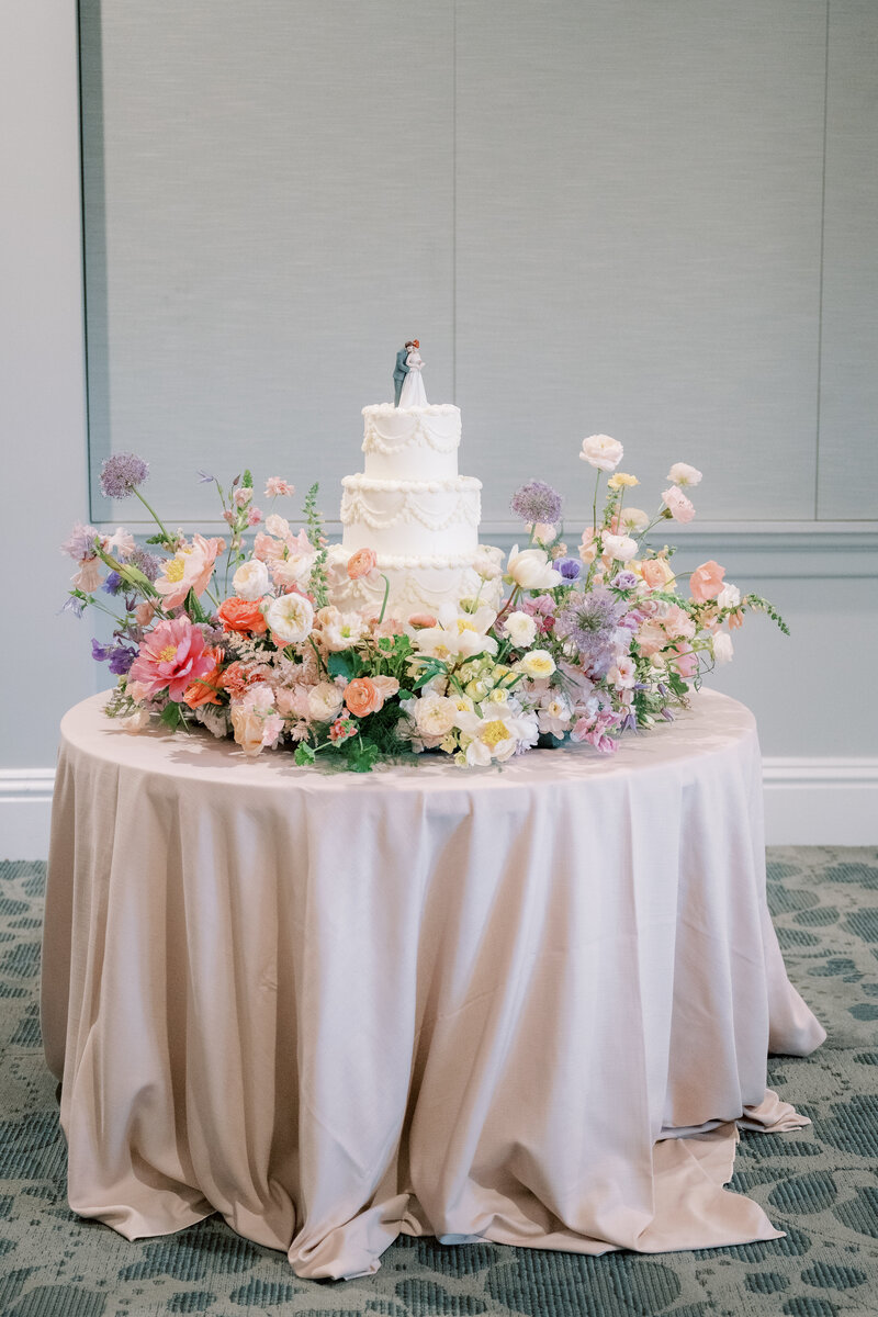 Bride holding pastel bouquet with lace dress details.