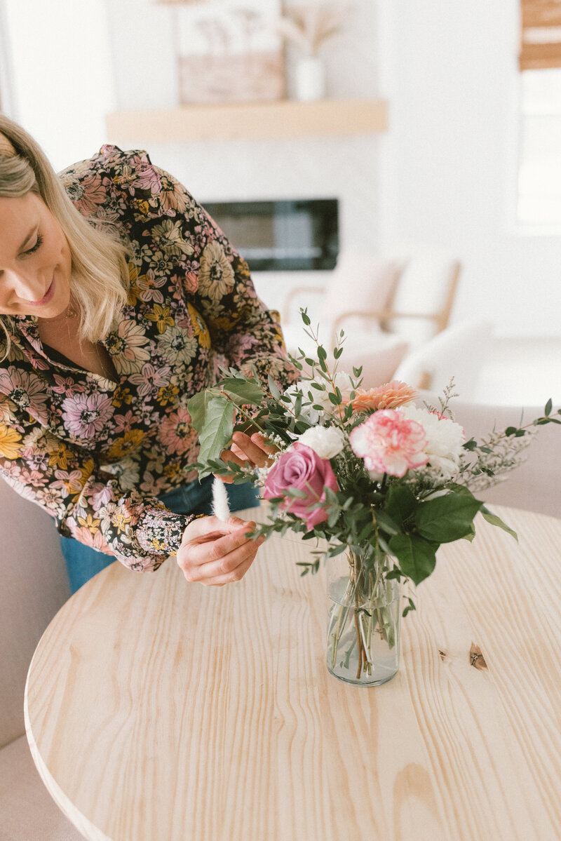 Sarah Kaetterhenry arranging flowers in home real estate open house