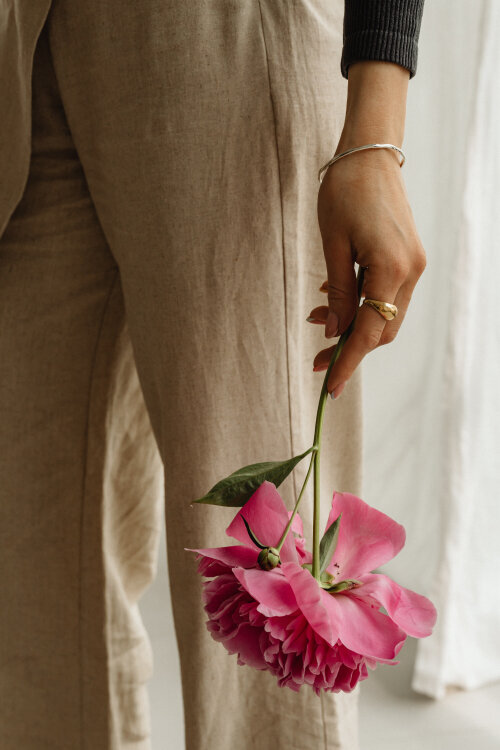 woman holding a pink peony