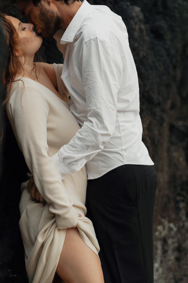 Couple leaning in for a kiss during an engagement session in Tofino at Long Beach by Latitude 49 Photography.