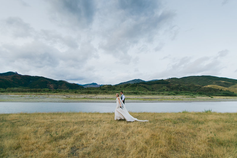Landscape of hills and river with bride and groom