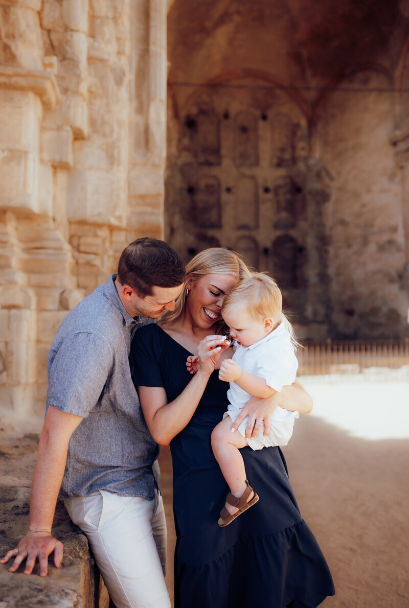 A family of three snuggled up to one another at Mission San Juan. 