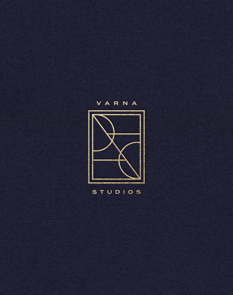 Contemporary gold emblem for Varna Studios on a dark blue textured background