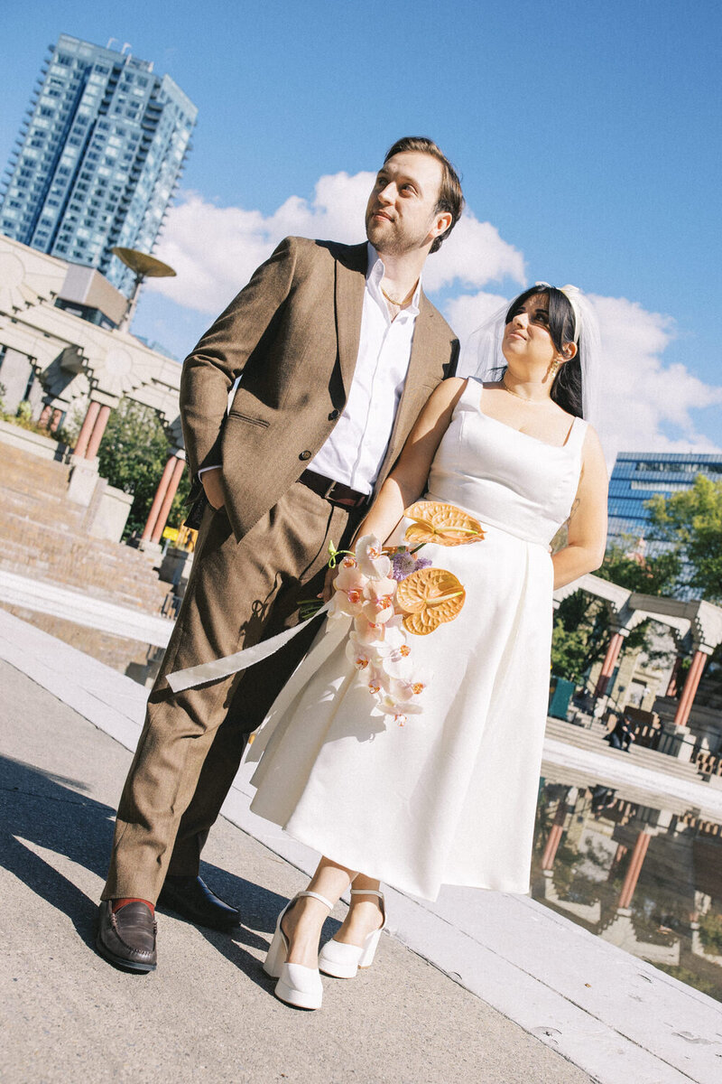 bride and groom leaning against each other in downtown calgary