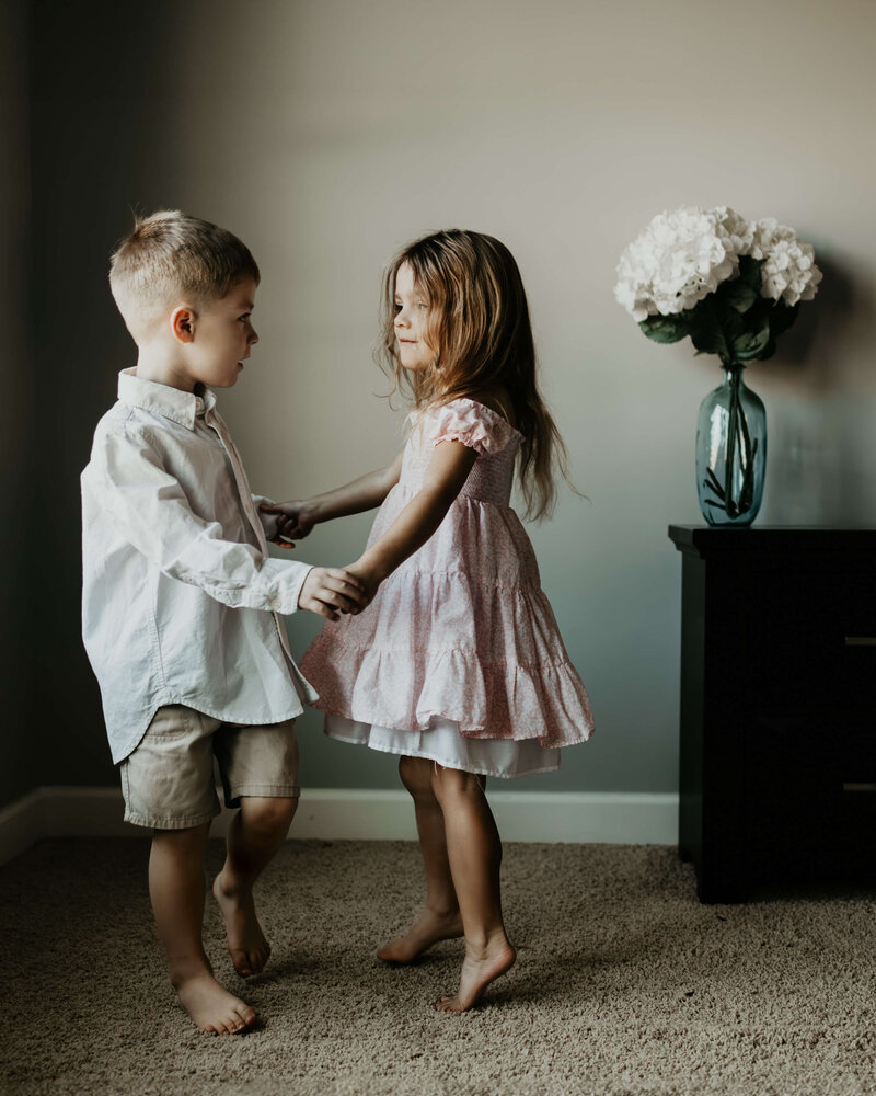 Little boy dances with his sister in their home during a family photo session in Pittsburgh