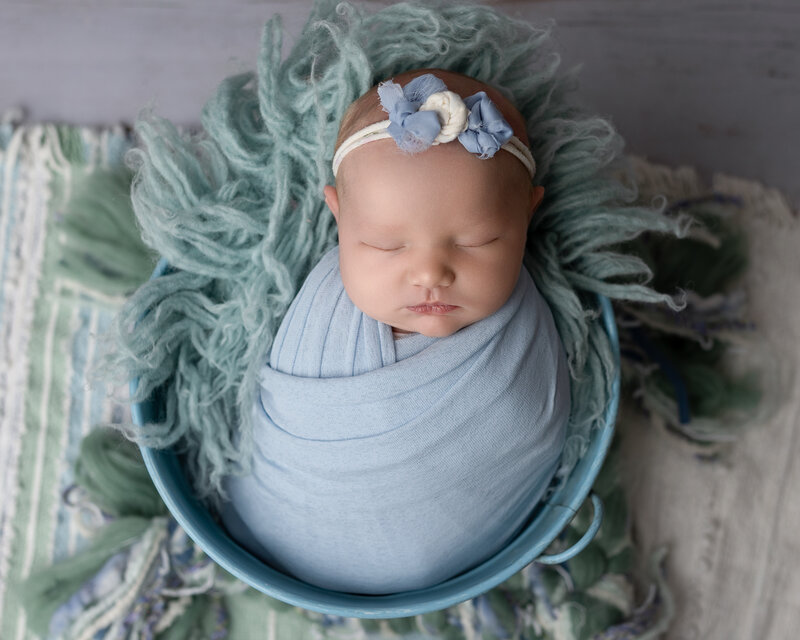 Canton newborn photo. Baby girl in blue in blue bucket.