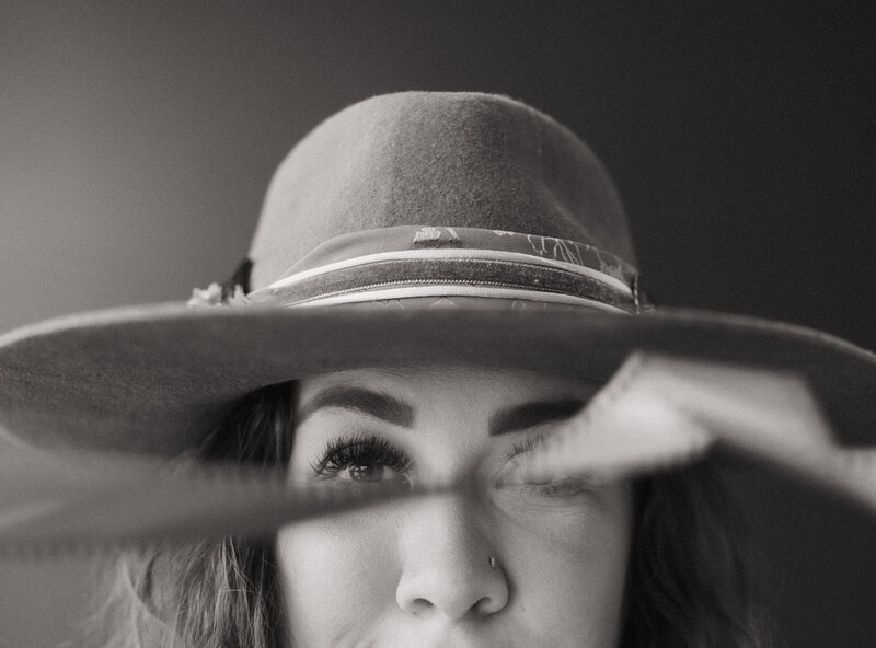 Photo of Jaime Denise owner of Jaime Denise Photography wearing hat smiling at camera