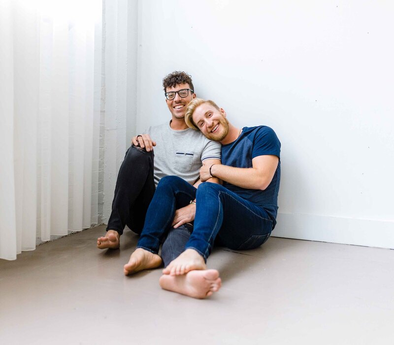 Gay couple in front of white wall