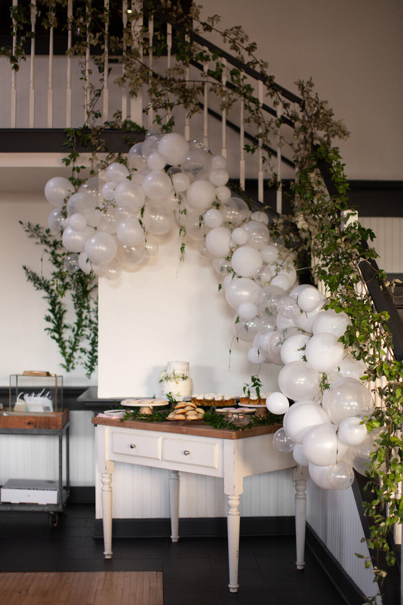 The Evergreen Event Space dessert station with white balloons set up