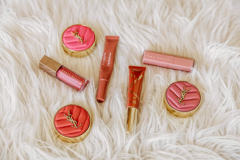 lip and cheek makeup products laid out in a fun way on a white fur surface in a studio in Oshkosh