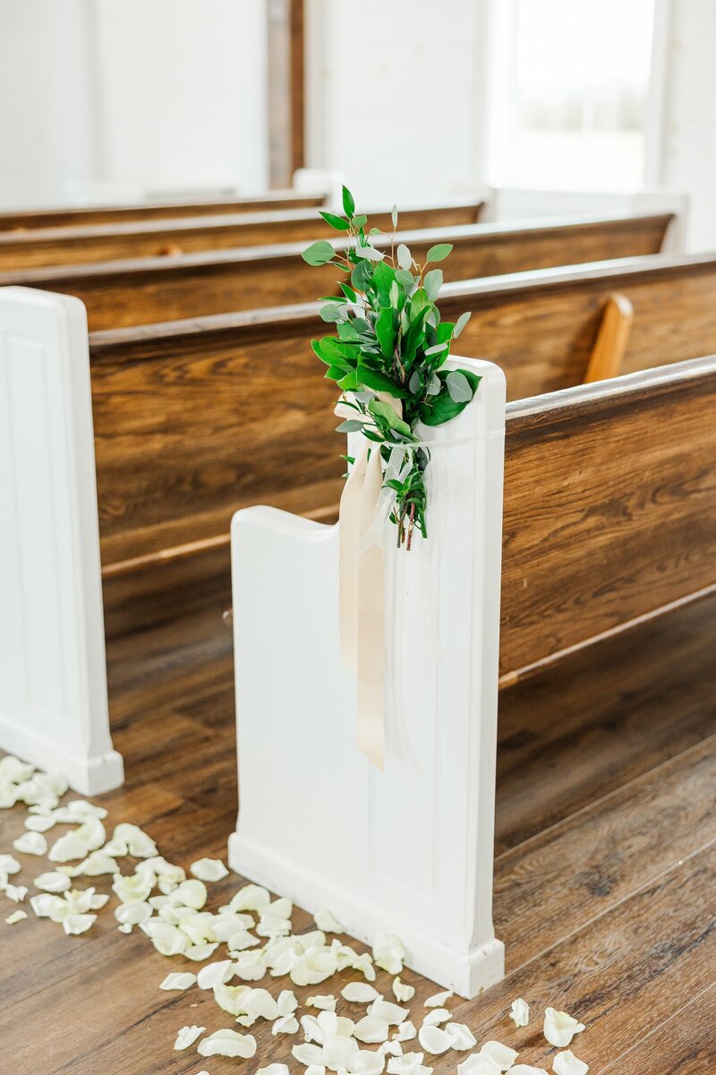 flower petals in the aisle of a church decorated for a wedding