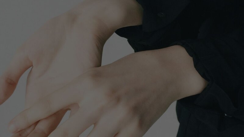 close up image of the hands of person wearing a black shirt