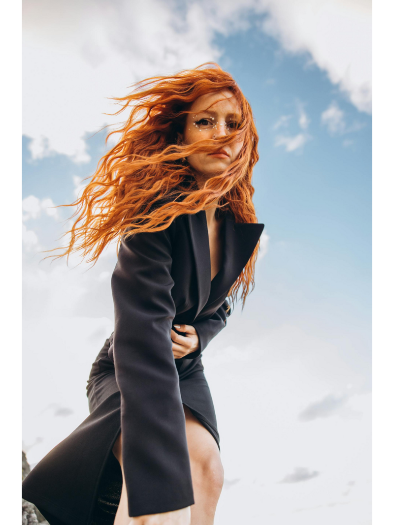 Red headed woman with wavy hair on the beach