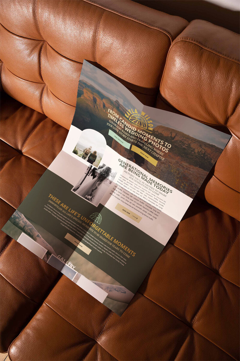 A poster depicting an elopement photographer website homepage resting on a deep sienna colored leather couch