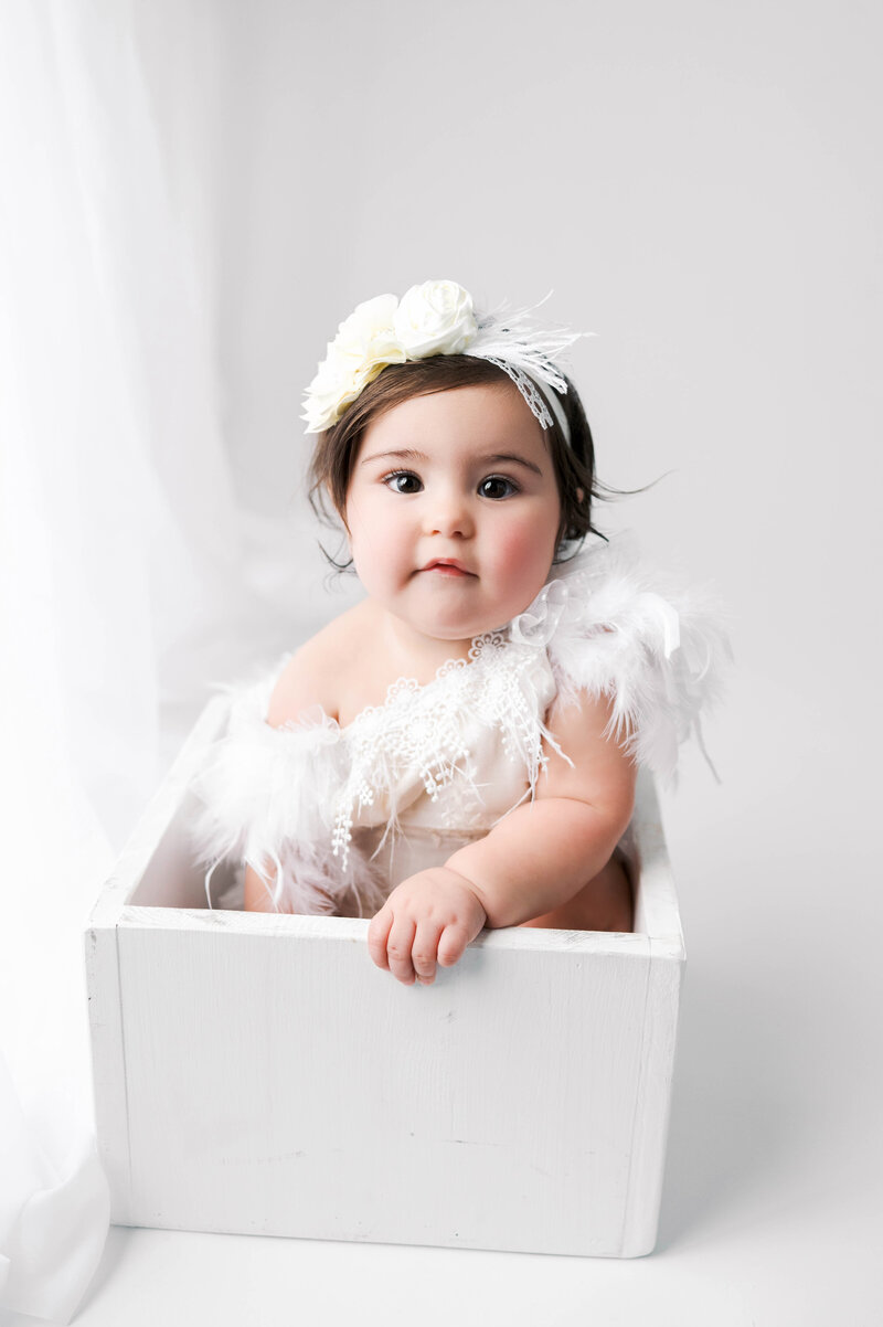 Birthday photo session baby girl white backdrop. 