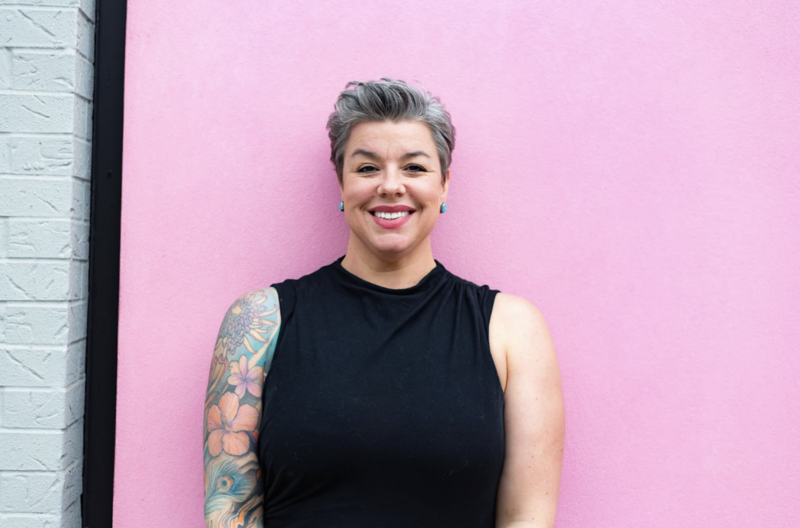 photo of Licensed Clinical Social Worker Chicago smiling while standing against a pink wall