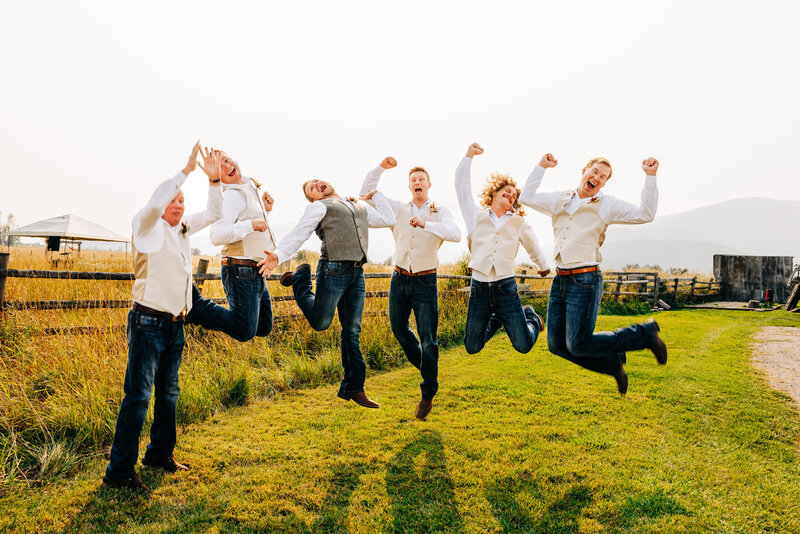 Groom and groomsmen jumping for joy at Cattle Springs venue in Arlee, MT