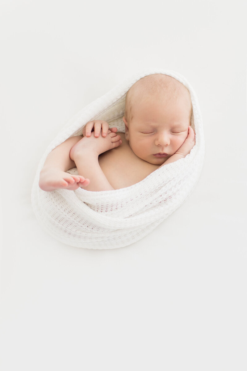 Portrait of Newborn in a white swaddle in Oklahoma City studio