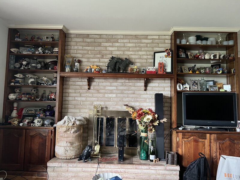 Before photo of Katie Fri Photography’s workspace with dark wood built-ins and cluttered shelves.