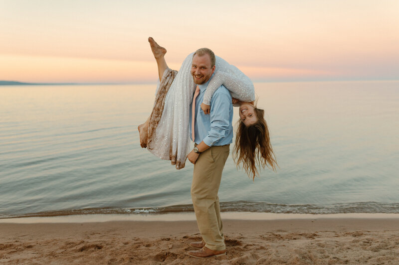 A couple taking photos on their elopement at Black Beach in Silver Bay, Minnesota