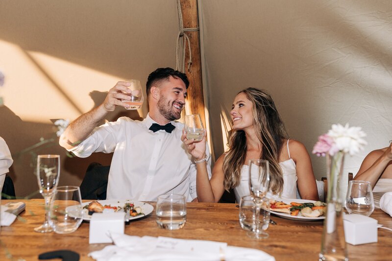 bride and groom cheers drinks in element tipis at their waipara vineyard wedding in christchurch