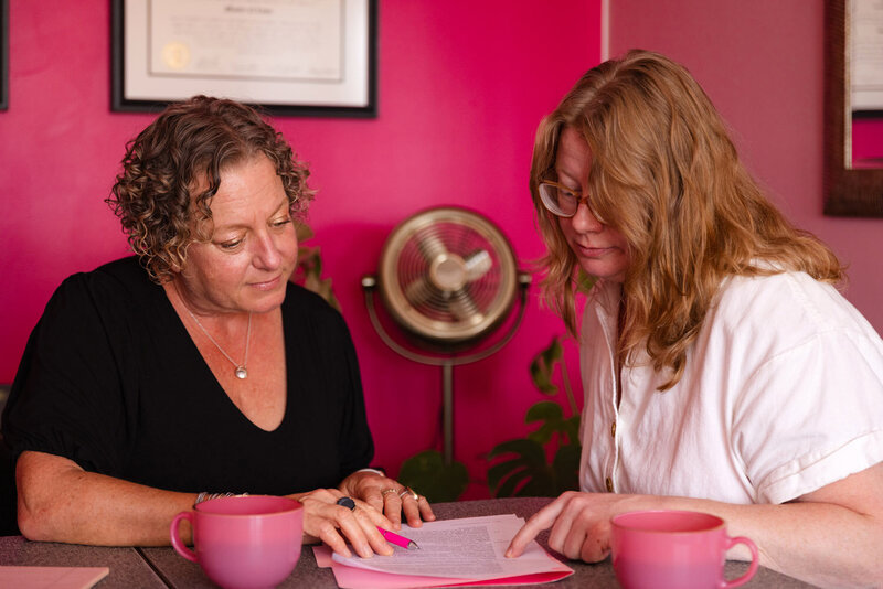 Cassie Peters, a business lawyer in Eugene, looks at papers with a client in her office. 